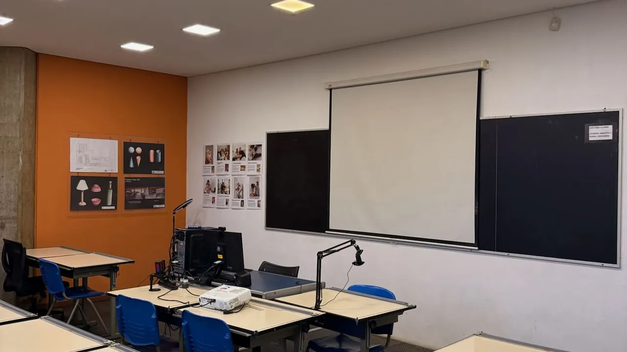 Sala de aula com projetor, mesas e equipamentos